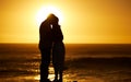 Mature couple bonding at sunset on the beach. Silhouette of senior couple being close on the beach. Mature married