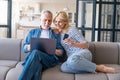 Mature couple buying online on website, using laptop with internet Royalty Free Stock Photo