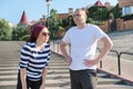 Mature couple in city near the stairs, middle-aged man and woman in sportswear talking resting after running