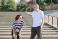 Mature couple in city near the stairs, middle-aged man and woman in sportswear talking resting after running