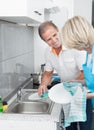 Mature Couple Cleaning Utensils Royalty Free Stock Photo