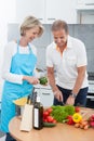 Mature couple cutting vegetables
