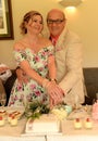 Mature couple cutting wedding cake