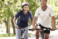 Mature Couple Cycling Through Park