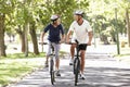 Mature Couple Cycling Through Park Royalty Free Stock Photo