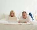 Mature couple with digital addiction at home. Man with tablet and woman with laptop Royalty Free Stock Photo