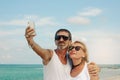 Mature couple doing a self-portrait at the beach