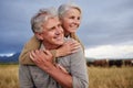 Mature couple embracing and looking happy while bonding outdoors at a farm, carefree and loving. Senior husband and wife Royalty Free Stock Photo