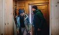 Mature couple entering wooden hut, holiday in winter nature concept.