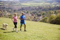 Mature Couple With Golden Retriever Jogging In Countryside Royalty Free Stock Photo