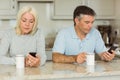 Mature couple having coffee and using phones Royalty Free Stock Photo