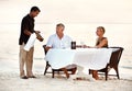 Mature couple having dinner at the beach. Shot of a mature couple enjoying a romantic dinner on the beach. Royalty Free Stock Photo