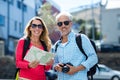 Mature couple holding map and camera in city Royalty Free Stock Photo