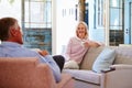 Mature Couple At Home Relaxing In Lounge With Hot Drink Royalty Free Stock Photo