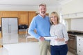 Mature Couple Looking Around Kitchen Of House For Sale