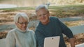 Mature couple in love taking selfie in forest on autumn day. Video call or browsing old photos Royalty Free Stock Photo