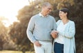 Mature couple, love and walking in garden for happy date, holiday and relax in retirement. Man, woman and holding hands Royalty Free Stock Photo