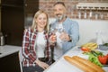 Mature couple making toast with glasses of water on kitchen Royalty Free Stock Photo