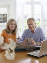 Mature couple With Map And Laptop At Home Royalty Free Stock Photo