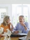 Mature couple With Map And Laptop At Home Royalty Free Stock Photo