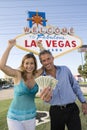 Mature Couple With Money And Welcome Sign In The Background Royalty Free Stock Photo