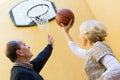 Mature couple playing basketball in patio Royalty Free Stock Photo