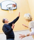 Mature couple playing basketball in patio Royalty Free Stock Photo