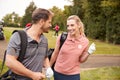 Mature Couple Playing Round Of Golf Carrying Golf Bags And Talking Royalty Free Stock Photo