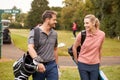 Mature Couple Playing Round Of Golf Carrying Golf Bags And Talking Royalty Free Stock Photo