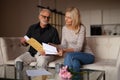 Mature couple reading bank notice, disappointed with payout. Bad news, financial bills Royalty Free Stock Photo