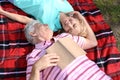 Mature couple reading book in park on spring day Royalty Free Stock Photo