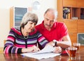 Mature couple reading financial document Royalty Free Stock Photo