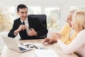 Mature couple at a reception with a lawyer. The lawyer holds a bundle of money and smiles. Royalty Free Stock Photo