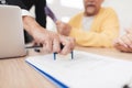 Mature couple at a reception with a lawyer. The lawyer puts a seal on the contract, the old people are happy about this.