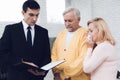 Mature couple at a reception with a lawyer. The lawyer reads a document. The old people are upset. Royalty Free Stock Photo