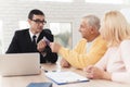 Mature couple at a reception with a lawyer. The old man and the lawyer are holding a bundle of money. Royalty Free Stock Photo