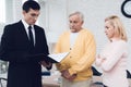 Mature couple at a reception with a lawyer. The lawyer reads a document. The old people are upset. Royalty Free Stock Photo