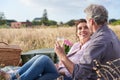 Mature, couple relax and picnic in park on date with love, care or support in marriage. Outdoor, man and woman on grass