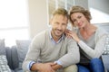 Mature couple relaxing at home on sofa