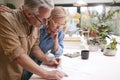 Mature Couple Reviewing And Signing Domestic Finances And Investment Paperwork In Kitchen At Home Royalty Free Stock Photo