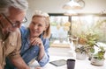 Mature Couple Reviewing And Signing Domestic Finances And Investment Paperwork In Kitchen At Home Royalty Free Stock Photo