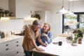 Mature Couple Reviewing And Signing Domestic Finances And Investment Paperwork In Kitchen At Home Royalty Free Stock Photo