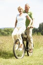 Mature couple riding bike in countryside Royalty Free Stock Photo