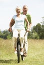 Mature couple riding bike in countryside Royalty Free Stock Photo