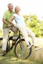 Mature couple riding bike in countryside Royalty Free Stock Photo