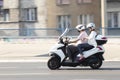 Mature couple riding on a three wheels motorbike and a woman is looking at her wrist watch Royalty Free Stock Photo