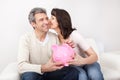 Mature couple saving money in piggybank Royalty Free Stock Photo