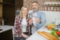 Mature couple sitting on kitchen with glasses of fresh water Royalty Free Stock Photo