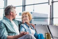 Mature couple sitting while waiting for their flight in airport Royalty Free Stock Photo