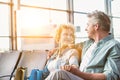 Mature couple sitting while waiting for their flight in airport Royalty Free Stock Photo